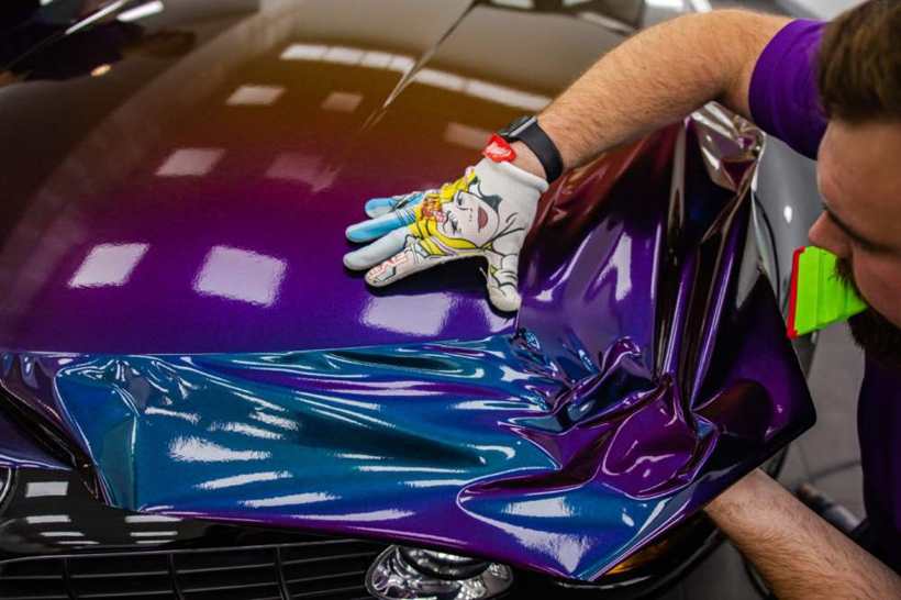 Fitter applying vinyl by hand